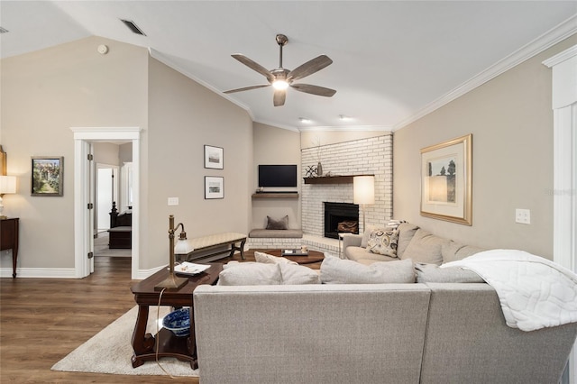 living area featuring a fireplace, visible vents, ornamental molding, vaulted ceiling, and wood finished floors