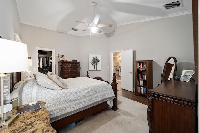 bedroom featuring a spacious closet, visible vents, and crown molding