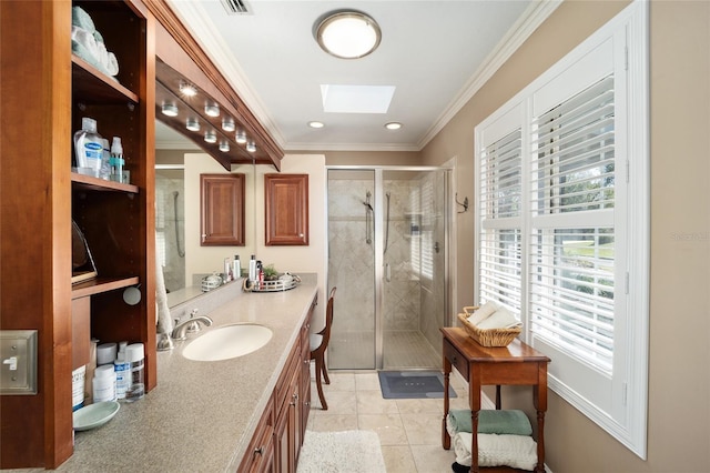 bathroom featuring a skylight, vanity, crown molding, and a stall shower