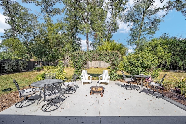 view of patio with an outdoor fire pit, fence, and outdoor dining space