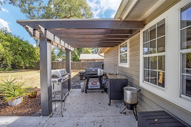 view of patio / terrace with a sink, fence, and a pergola