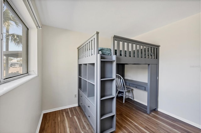 unfurnished bedroom featuring dark hardwood / wood-style flooring and built in desk