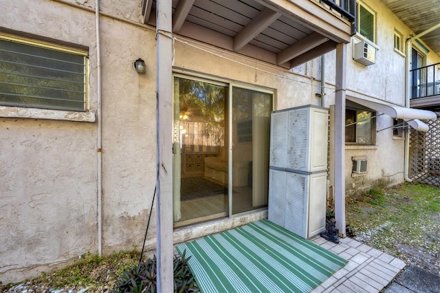 view of exterior entry with a wall mounted air conditioner