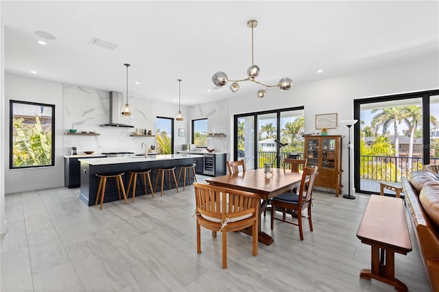 dining room with an inviting chandelier, sink, and a wealth of natural light