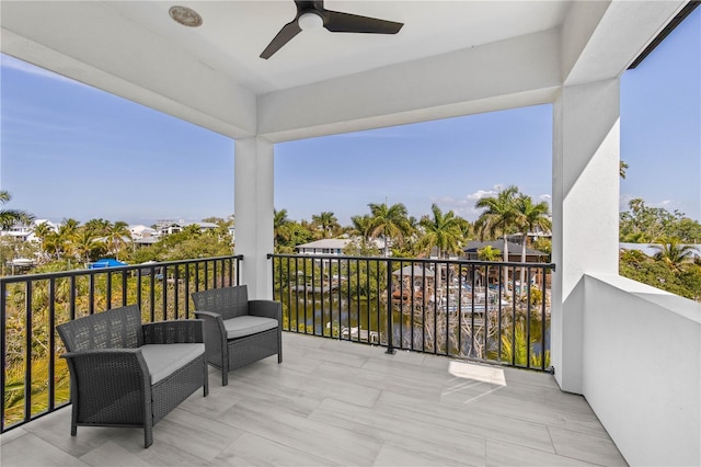 balcony featuring ceiling fan and a water view