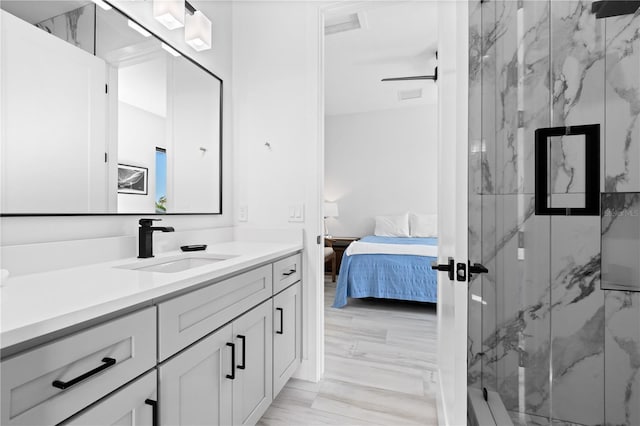 bathroom featuring an enclosed shower and sink