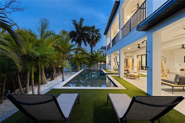 view of pool featuring a patio, ceiling fan, and a lawn