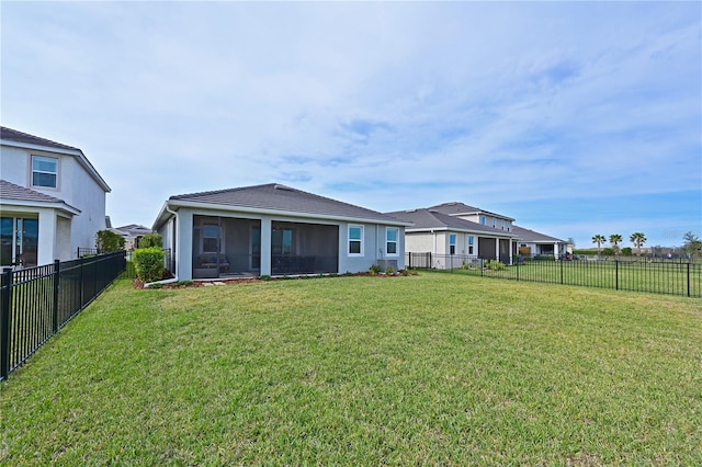 back of property featuring a yard and a sunroom