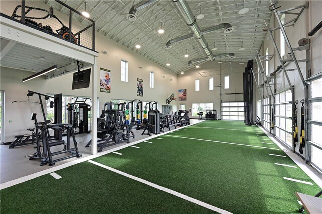 exercise room with a towering ceiling and a healthy amount of sunlight