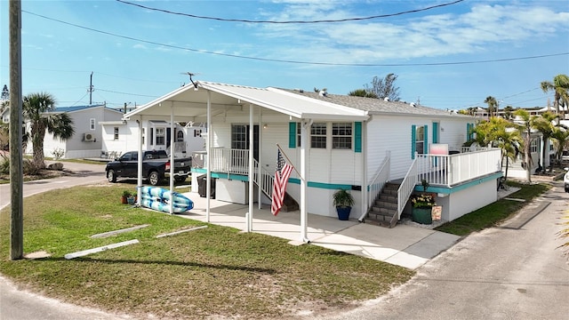 manufactured / mobile home featuring concrete driveway and a front yard