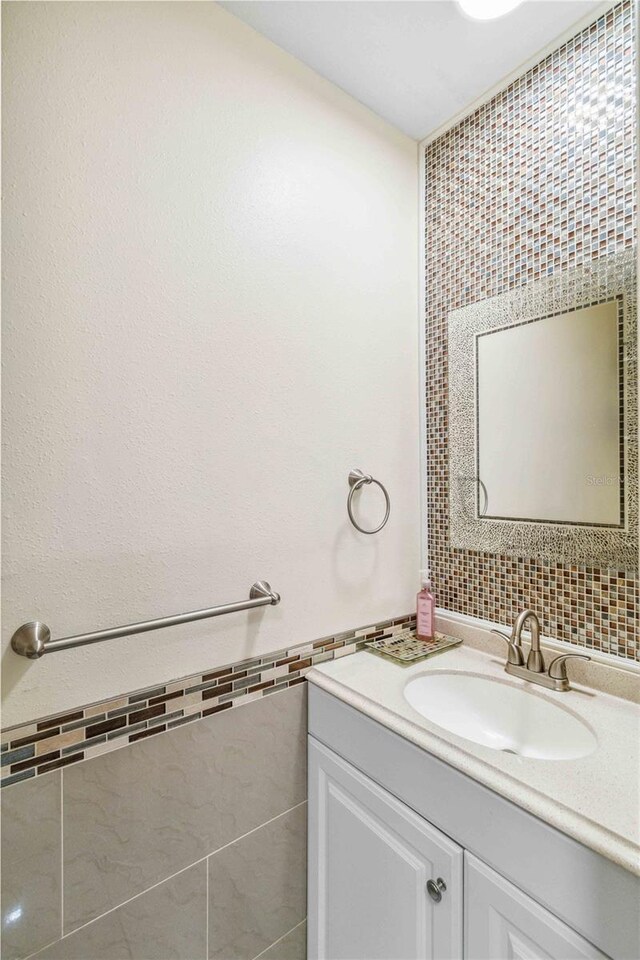 bathroom featuring vanity and tile walls