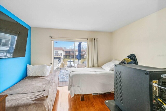 bedroom featuring access to exterior and wood-type flooring