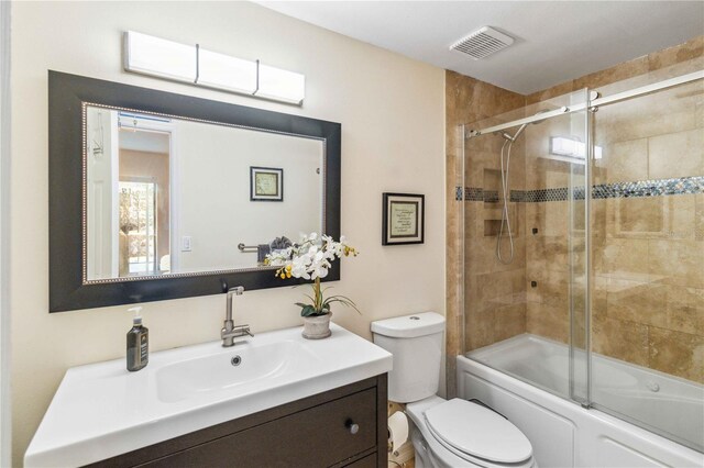 full bathroom featuring vanity, toilet, and combined bath / shower with glass door