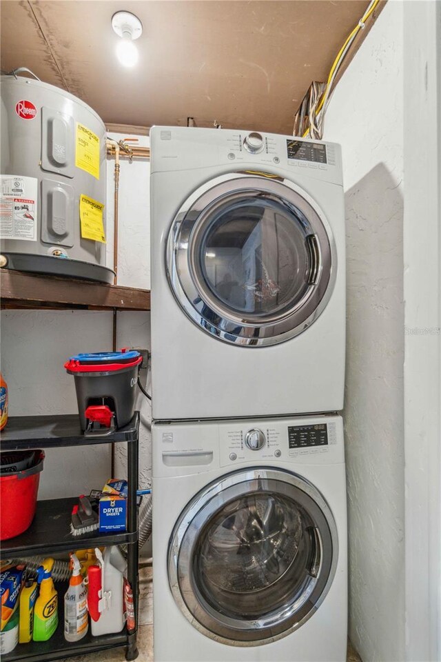 clothes washing area with water heater and stacked washing maching and dryer