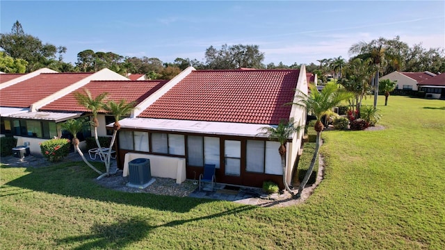 back of property featuring a yard and central air condition unit