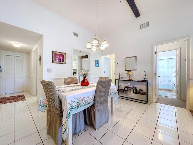 tiled dining space featuring beamed ceiling, an inviting chandelier, and high vaulted ceiling