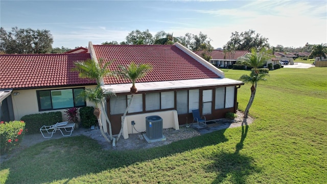 exterior space with cooling unit and a lawn