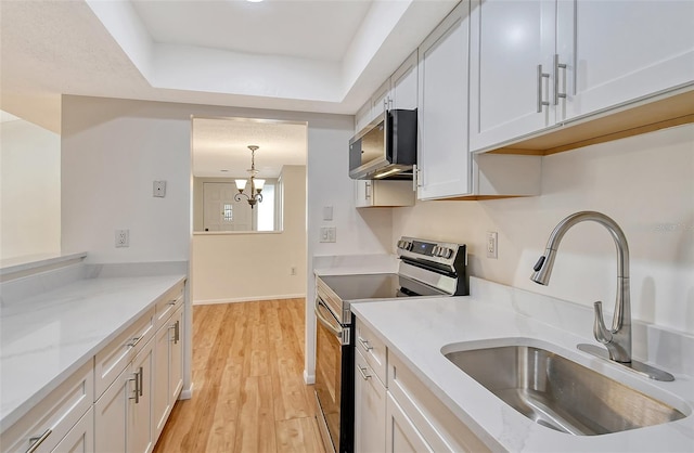 kitchen with sink, stainless steel electric range, hanging light fixtures, white cabinets, and light wood-type flooring