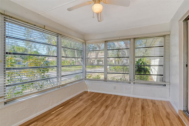 unfurnished sunroom featuring ceiling fan