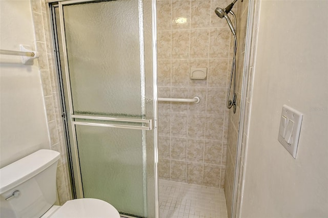 bathroom with toilet and an enclosed shower