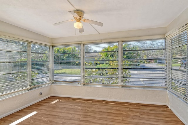 unfurnished sunroom with ceiling fan