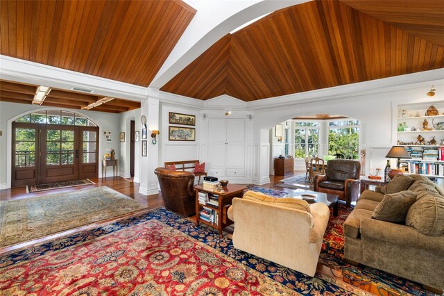 16475 Captiva Dr, Captiva, FL 33924 - living area featuring arched walkways, healthy amount of natural light, high vaulted ceiling, wood finished floors, and built in features