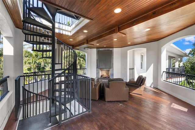 16475 Captiva Dr, Captiva, FL 33924 - living room featuring a warm lit fireplace, dark wood-style flooring, healthy amount of natural light, recessed lighting, and wooden ceiling