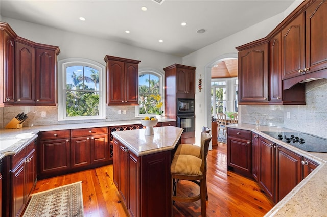16475 Captiva Dr, Captiva, FL 33924 - kitchen with black appliances, reddish brown cabinets, plenty of natural light, and recessed lighting