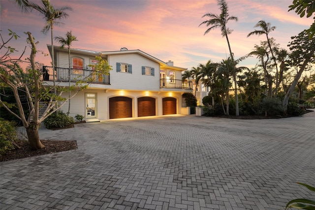 16475 Captiva Dr, Captiva, FL 33924 - view of front facade with a balcony, decorative driveway, and a garage
