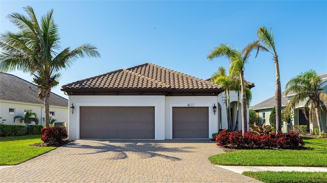 mediterranean / spanish home featuring a garage and a front yard