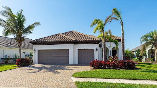 mediterranean / spanish house with a garage and a front yard