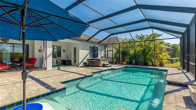 view of pool with a hot tub, a patio, and glass enclosure