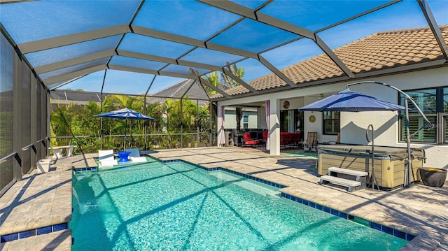 view of pool featuring a lanai, a patio area, and a hot tub