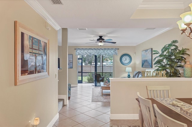 tiled dining area with ceiling fan and ornamental molding