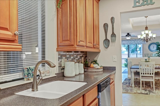 kitchen with sink, hanging light fixtures, stainless steel dishwasher, ornamental molding, and decorative backsplash