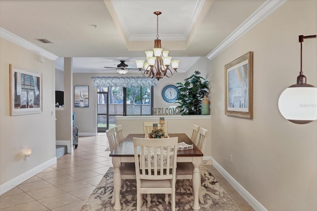 tiled dining room with ornamental molding, a tray ceiling, and a notable chandelier