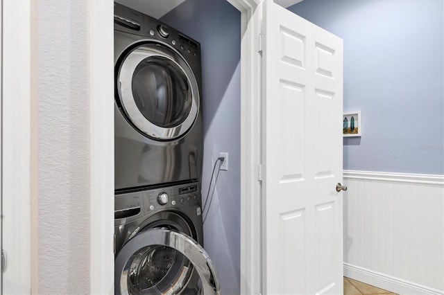 clothes washing area featuring stacked washer / dryer and light tile patterned floors