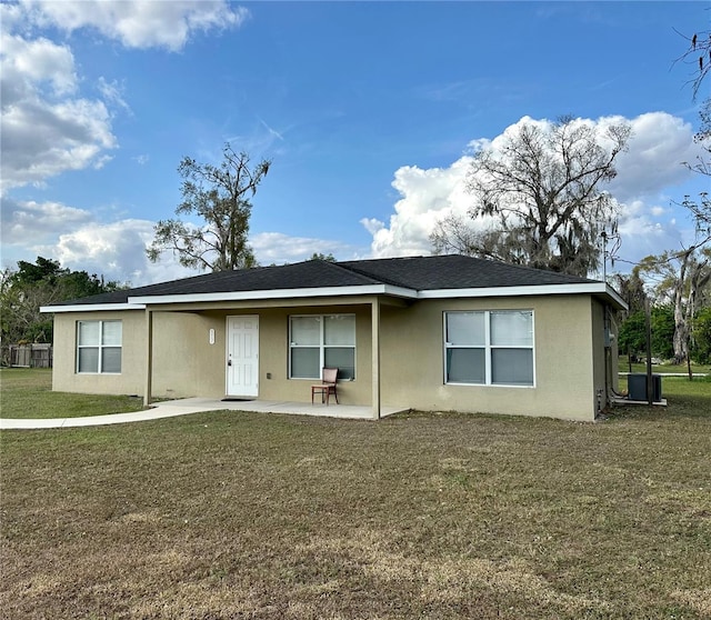 rear view of property featuring a yard and a patio