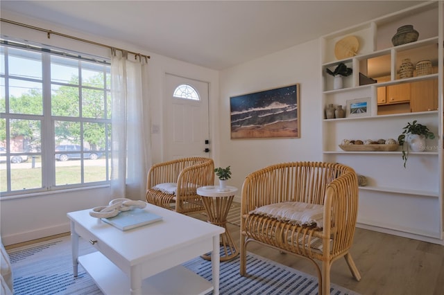 living area with a wealth of natural light and light hardwood / wood-style floors