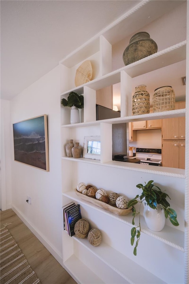 interior details with electric range oven and wood-type flooring