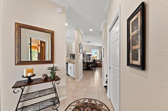 corridor featuring ornamental molding and light tile patterned floors