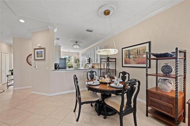 dining room featuring crown molding and light tile patterned floors