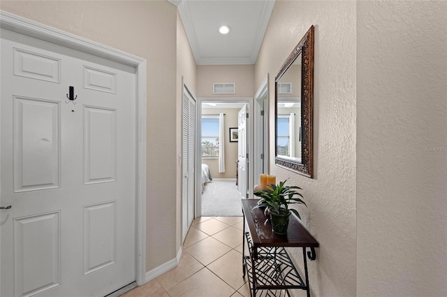 hallway featuring crown molding and light tile patterned floors