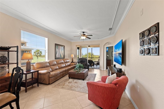 tiled living room with ornamental molding and ceiling fan