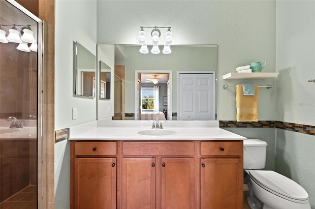 bathroom featuring vanity, an enclosed shower, and toilet