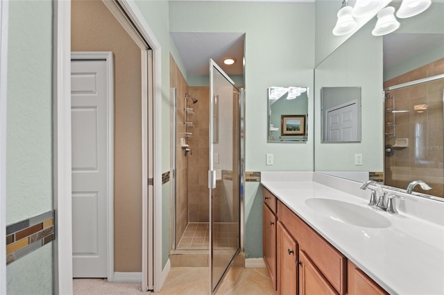 bathroom featuring vanity, tile patterned flooring, and a shower with shower door