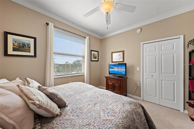 carpeted bedroom featuring crown molding, ceiling fan, and a closet