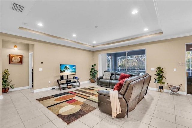 living room with light tile patterned floors, ornamental molding, and a raised ceiling