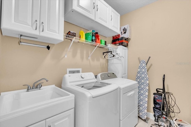 laundry room with washer and dryer, sink, cabinets, light tile patterned floors, and a textured ceiling