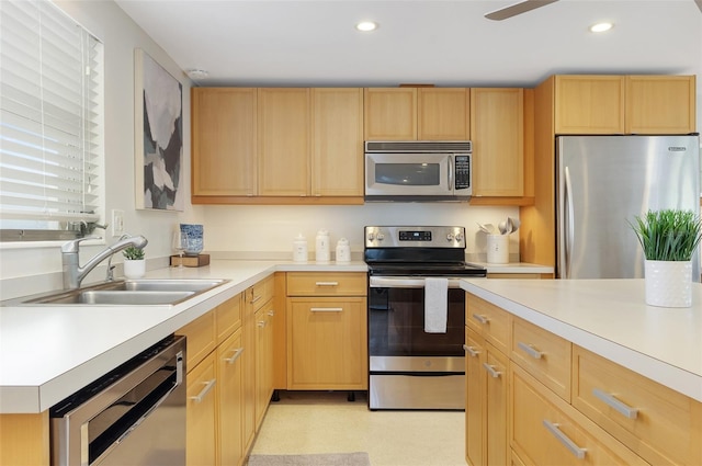 kitchen with appliances with stainless steel finishes, sink, and light brown cabinetry